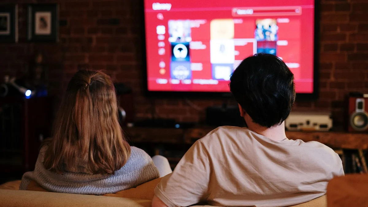 Two people watching a screen together in a dark room