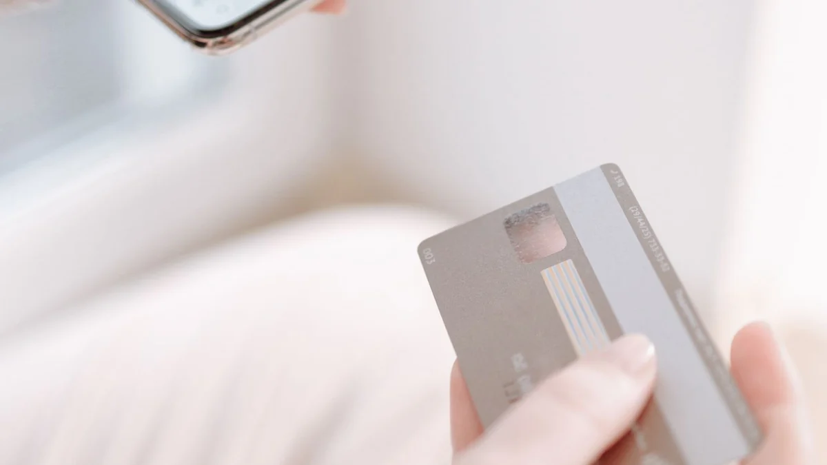 Hands holding a smartphone and a payment card