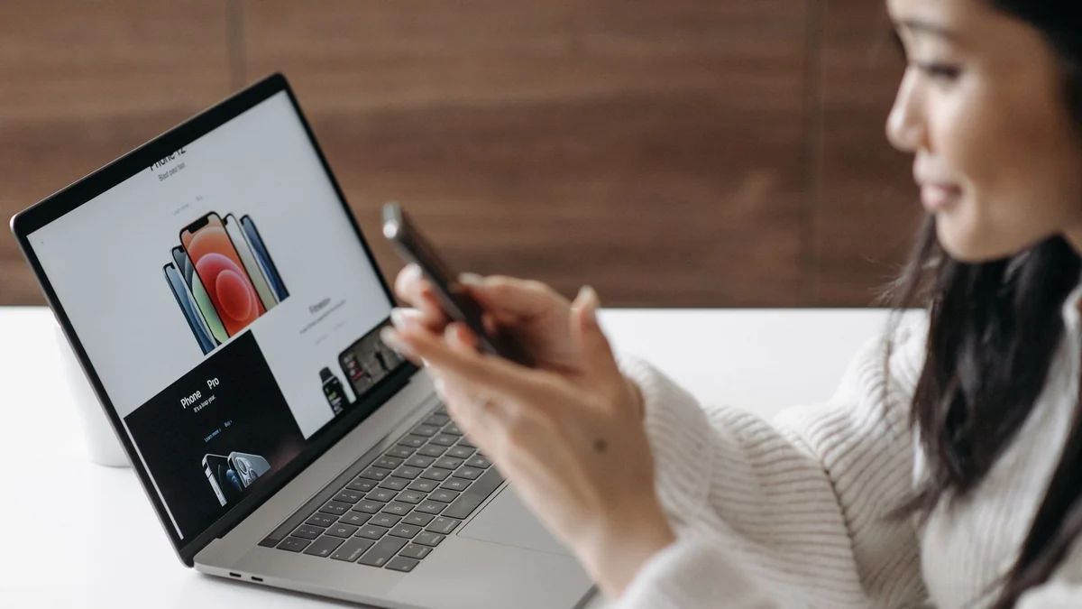 A person searching on a laptop and phone at home