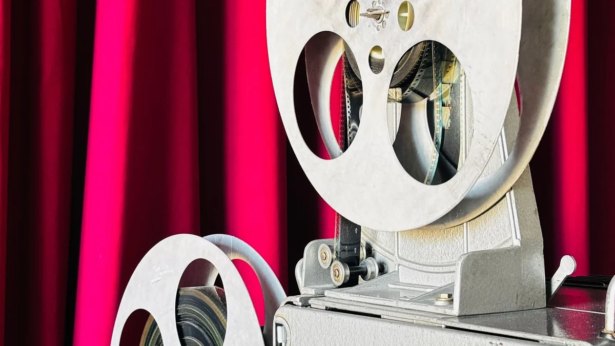 A film reel resting against a red theatre curtain
