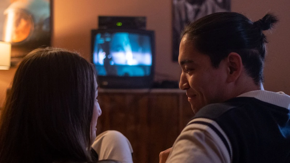 A couple watching a film together in a dimly lit living room