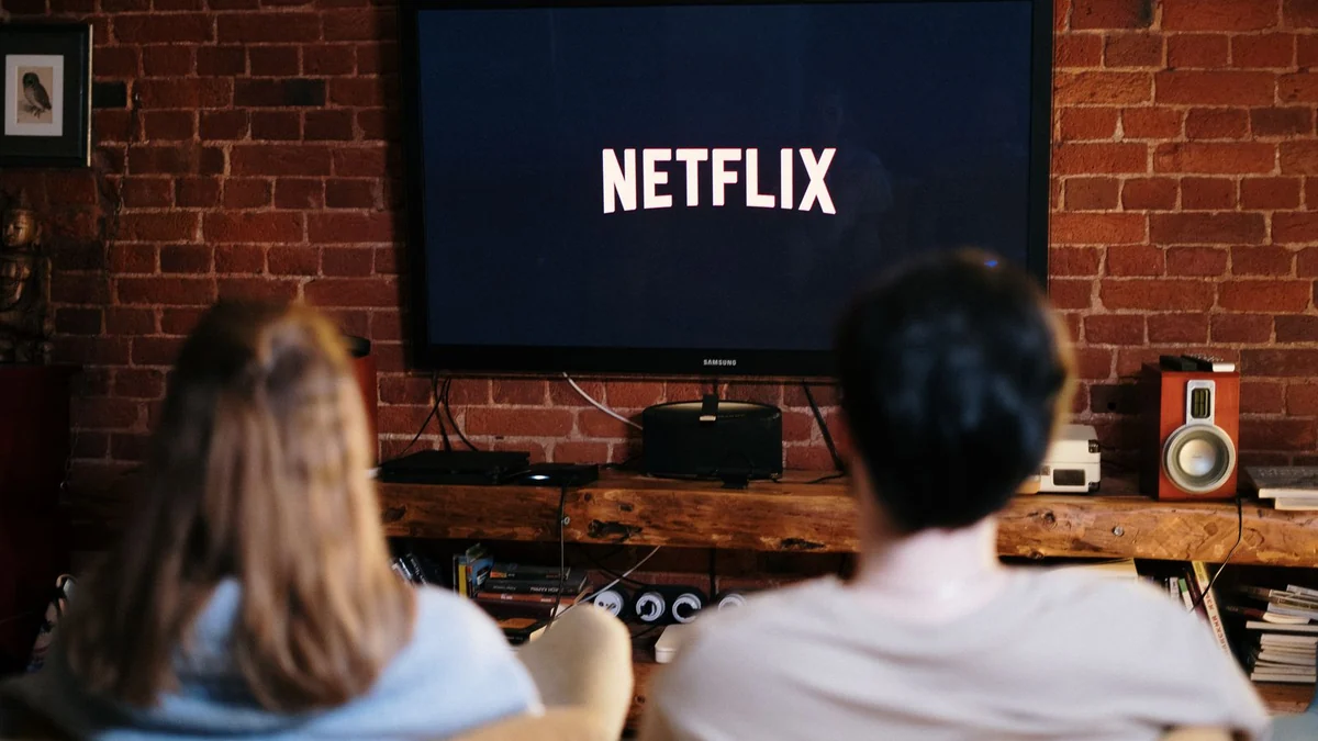 A person watching an animated film on a laptop in a cosy room