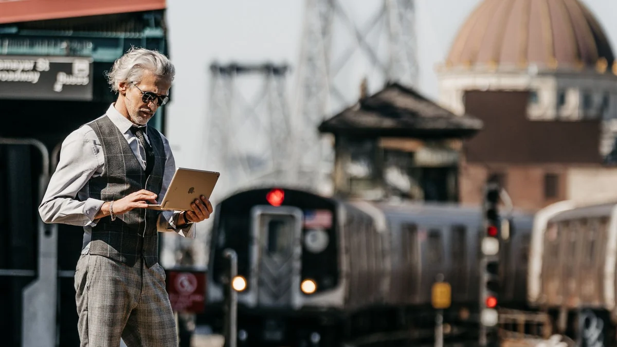 A man using a tablet at a railway station