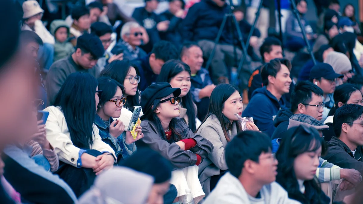 A diverse group of people watching an outdoor event