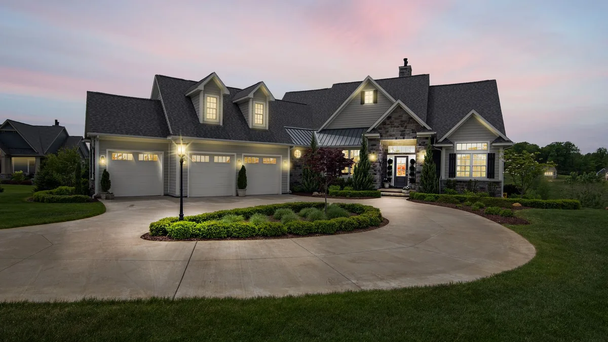A suburban house lit warmly at dusk