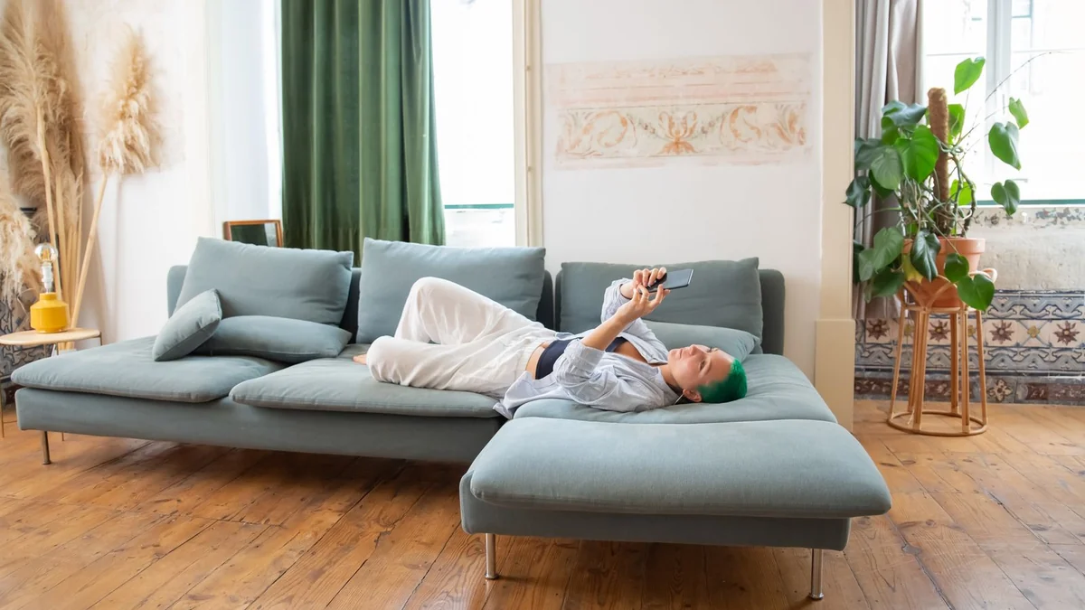 A person relaxing on a sofa looking at a phone