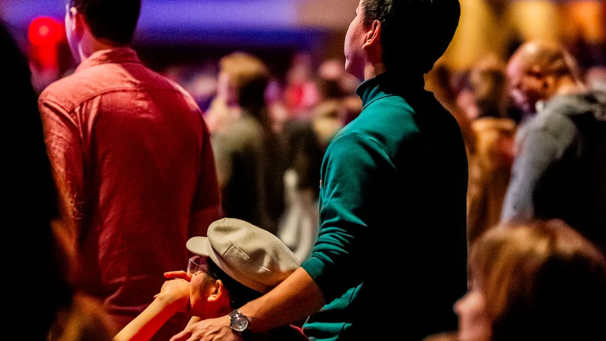An attentive audience seated in a dimly lit venue