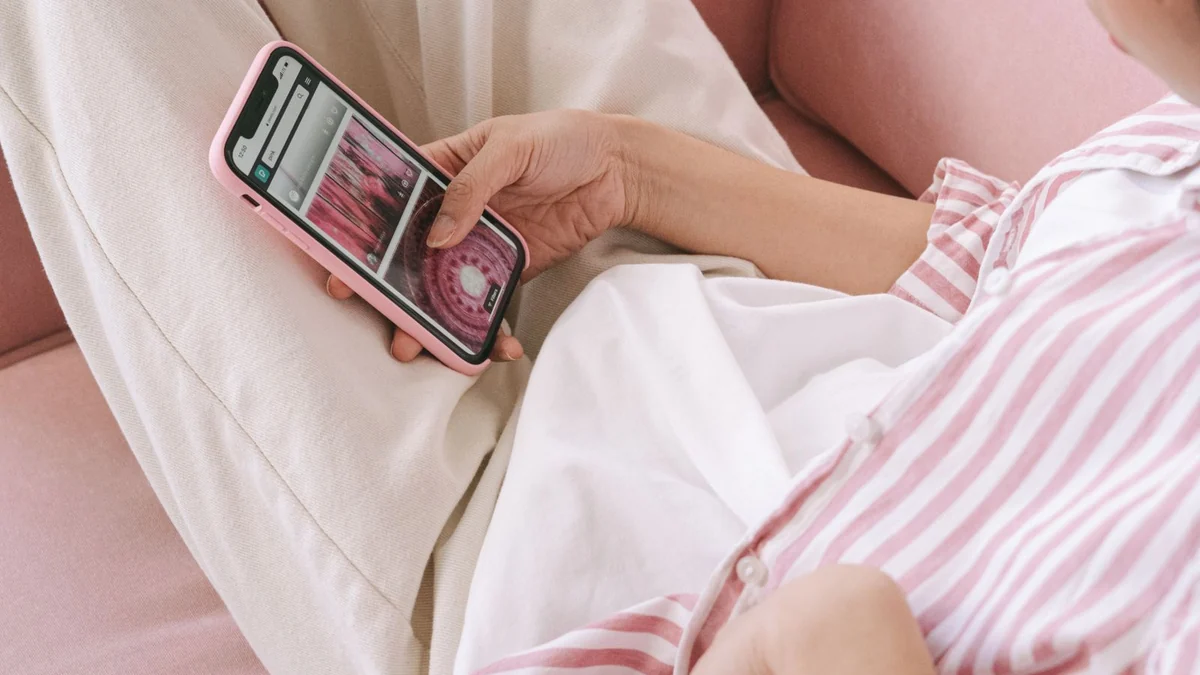 A woman sitting on a sofa searching on her phone