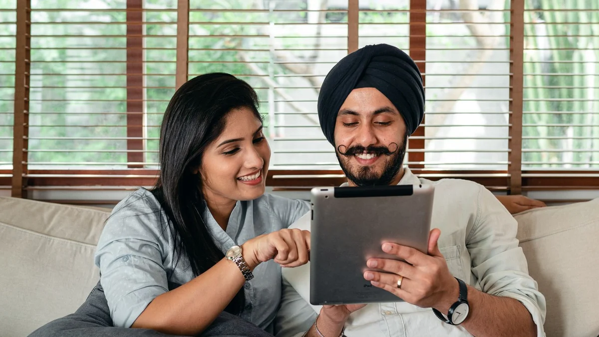 Two people watching a film together on a tablet at home