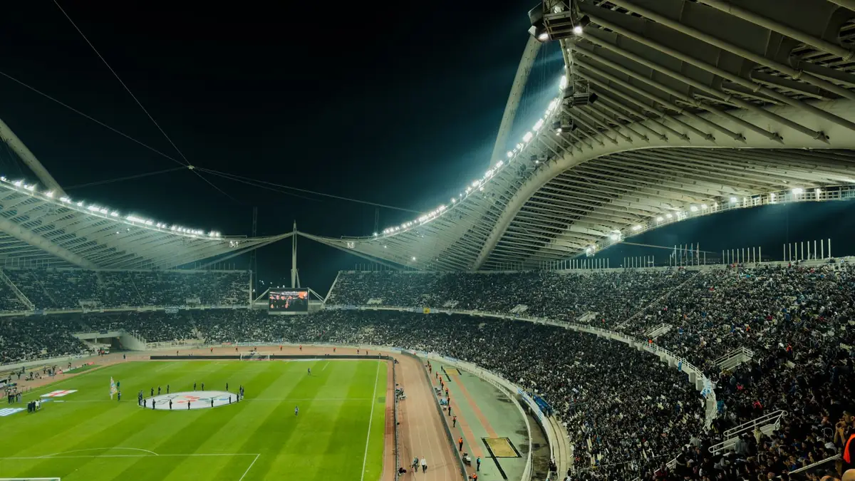 Football supporters watching a match under floodlights