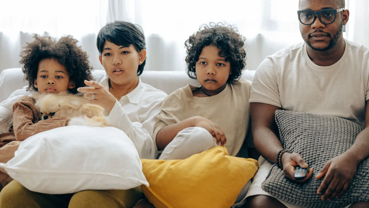 A family sitting together in a living room in the evening