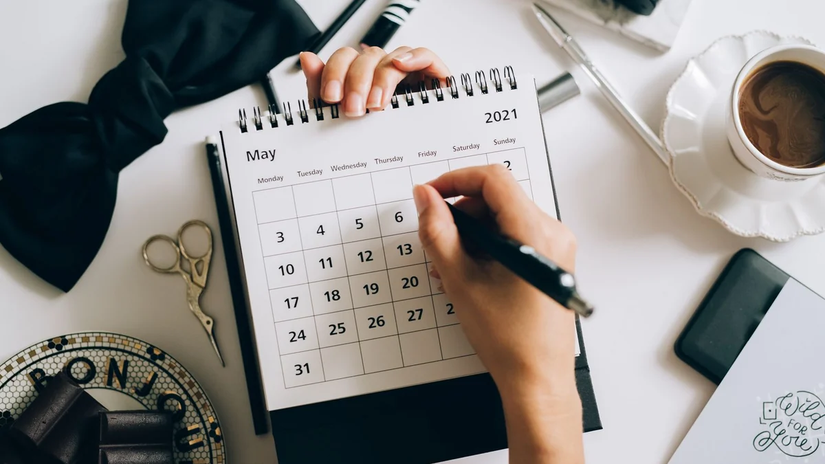 A calendar page beside a cup of coffee
