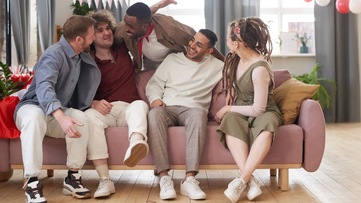 A group of friends laughing together on a sofa